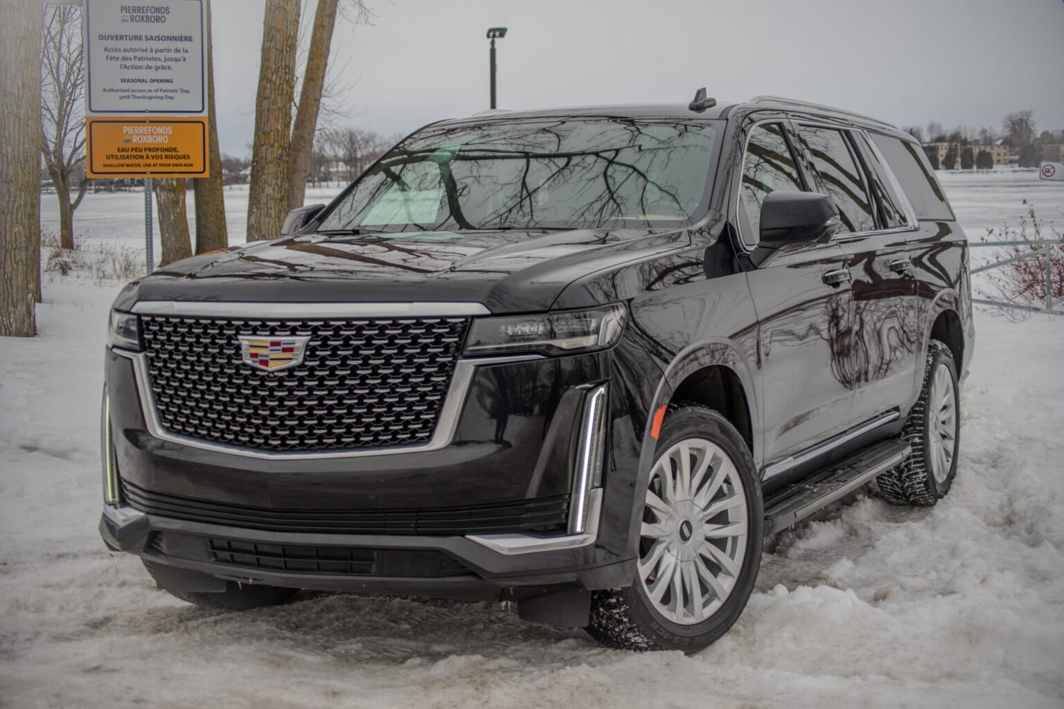 a black LIMOUSINE CADILLAC ESCALADE parked in the snow MONTREAL